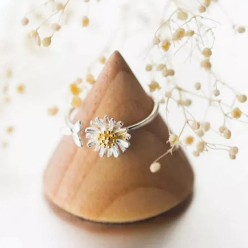 Daisy open adjustable ring on wood stand with dried flowers behind