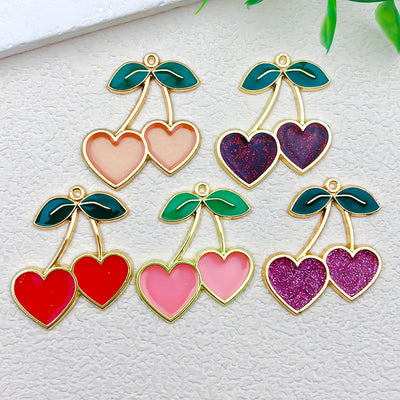 Metallic cherry charms arranged on a light background
