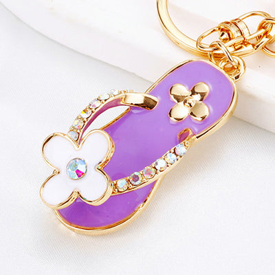 A front product view shows the mixed flip flop keychain with its visible ornament and hanging hardware.