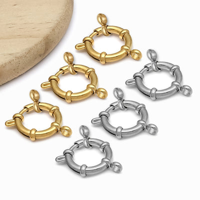 Gold-tone spring clasp jewelry findings arranged on a light background