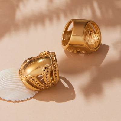 Styled hand view of sculptural wide open ring in gold tone in main image 1.