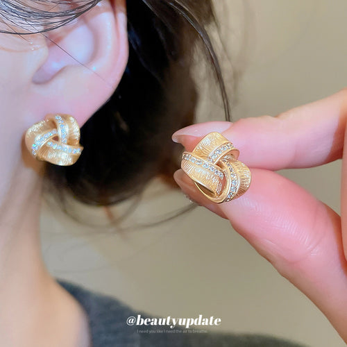 金色编结耳钉 shown worn at the ear or neckline