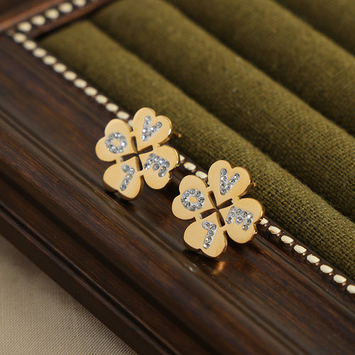 Pair of gold clover LOVE crystal stud earrings on green cushion