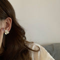 Floral Pearl Stud Earrings in White and Gold with Polished Metal Details view 4