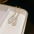 White Teardrop Dangle Earrings In Gold And Silver With Decorative Details view 6