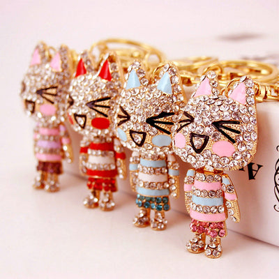 Four rhinestone cat figures displayed together with pink, red, and blue accents.