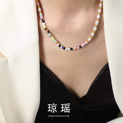 Model wearing multicolor stone and pearl beaded necklace under white blazer