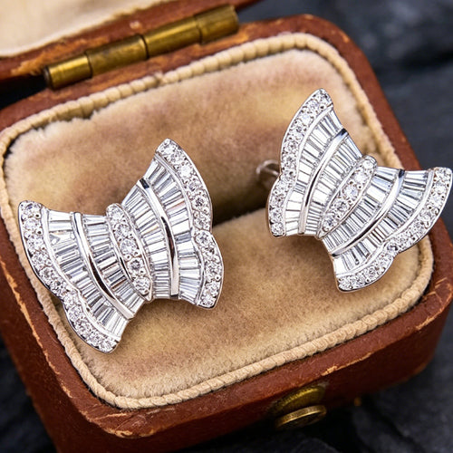 Pair of white gold bow fan studs angled inside velvet jewelry case