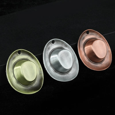 Three cowboy hat charms in antique bronze-green, antique silver and antique copper finishes on a black background
