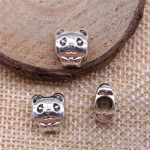 Rounded panda face with dark recessed details and a large hole displayed on a natural wood setting