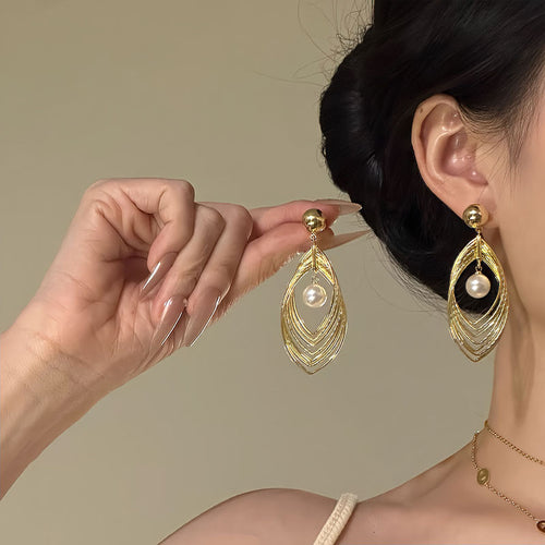 Close view of the colors and surface details on layered teardrop pearl drop earrings
