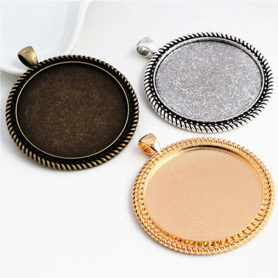 Grouped front view of round metal cabochon pendant trays in fifteen frame styles
