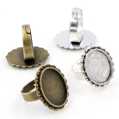 Overview of adjustable-look ring blanks topped by scalloped oval bezel settings in silver and antique bronze tones arran