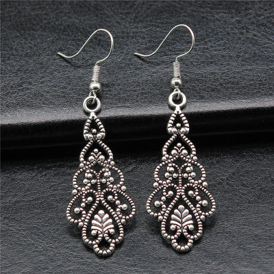 Close-up of filigree teardrop earrings showing ornate open teardrop drops on fishhook ear wires