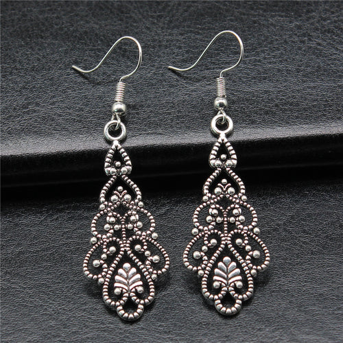 Close-up of filigree teardrop earrings showing ornate open teardrop drops on fishhook ear wires