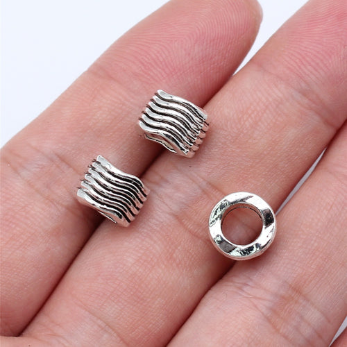 Close view of rippled barrel large-hole spacer bead in antique silver tone