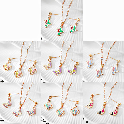 Grid of seven gold enamel butterfly and bird necklace earring jewelry sets