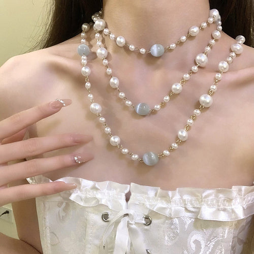 Layered white pearl-look strands mixed with silver-tone chain sections shown in a styled close-up