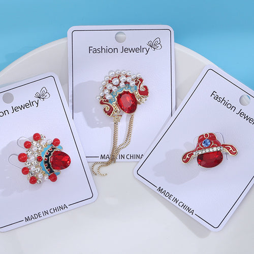 Three red opera headdress brooches on fashion jewelry cards