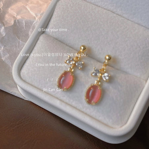 Pink cat eye oval drops with CZ bows in white jewelry tray