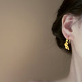 Gold Tone Curved Leaf Hook Earrings With Decorative Metal Details view 4