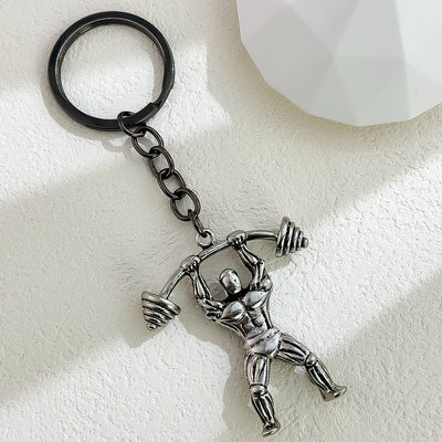Gunmetal metal weightlifter figure keychain holding a barbell overhead