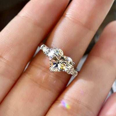 Product view showing silver-tone three-heart clear stone ring
