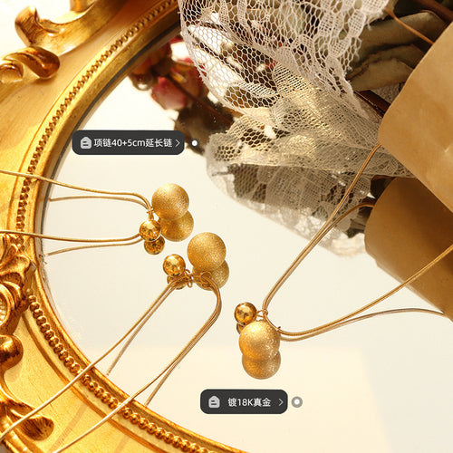 Gold matte ball pendants on mirror with length and plating labels