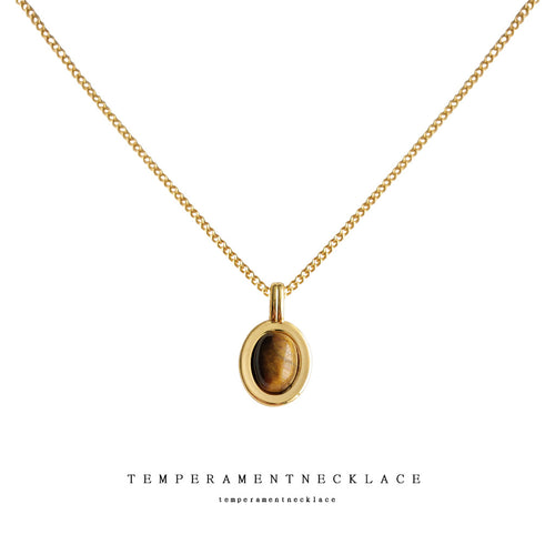 Gold-tone brown oval double-frame pendant necklace isolated on white.