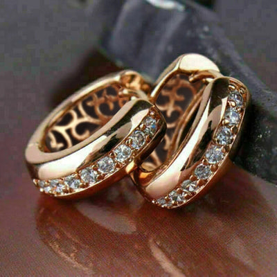 Pair of rose gold CZ channel hoops with filigree backs on dark surface