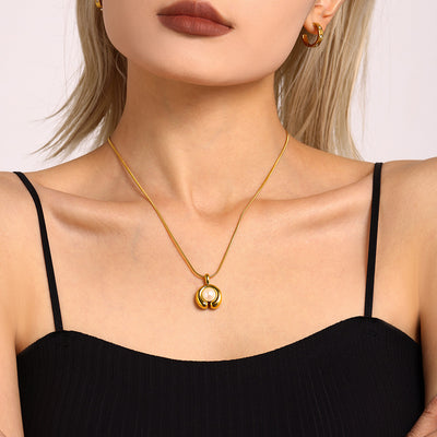 Model wearing gold C-shape pearl pendant snake chain necklace