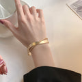 Matte Gold Tone Crossing Ribbon Open Cuff Bracelet view 1
