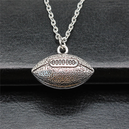 Close-up of american football pendant necklace showing a textured American football pendant on a chain