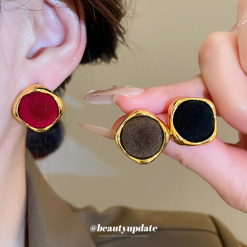 velvet square stud earrings in black and red with metal tone details shown in an on-ear styling view