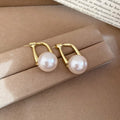 Gold Tone Curved Bar and Pearl Stud Earrings With Polished Metal Details view 1