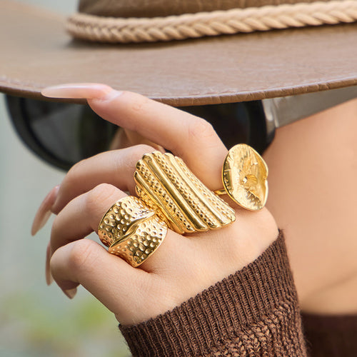 Grouped style view of textured sculptural gold tone statement rings in main image 2.