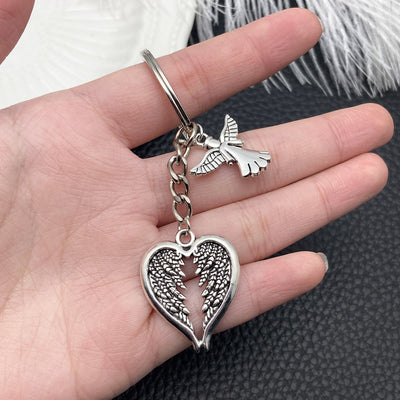 Front display of antique silver winged heart and dove keychain with visible colors and attached hardware