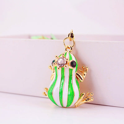Front angled view of the green and white striped frog charm with faceted stones.