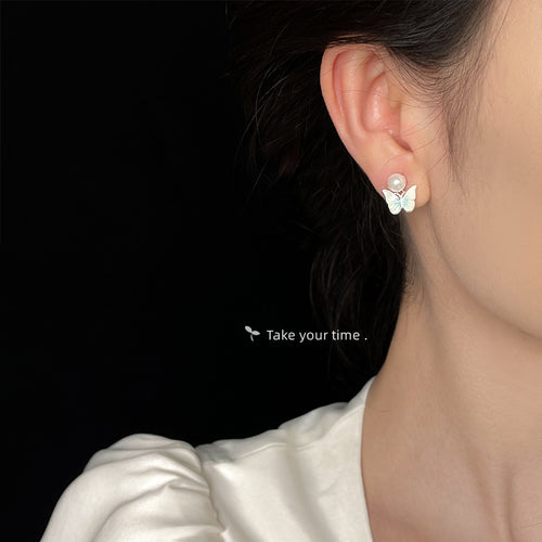 Light blue butterfly pearl stud worn on ear side profile
