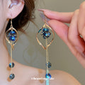 Blue Crystal Twisted Loop Dangle Hook Earrings with Polished Metal Details view 2