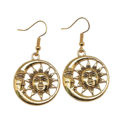 Close view of sun and moon cutout drop earrings in two metal finishes