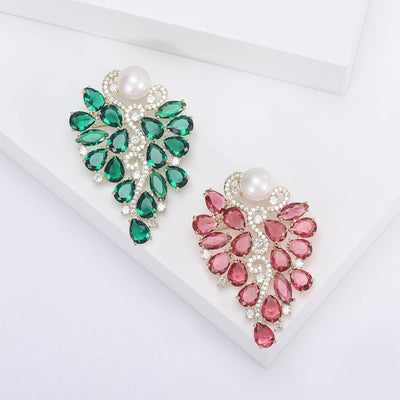 Front view of leaf-shaped crystal cluster topped with a single white pearl-like bead