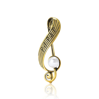Gold music note staff brooch with white pearl on white background