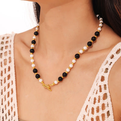 Model wearing black agate white shell gold OT toggle necklace