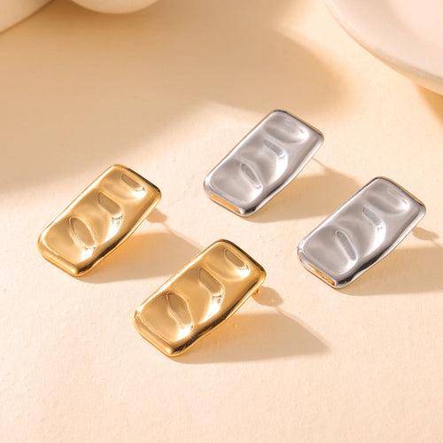 Close-up gold ruched rectangular stud earring on ear