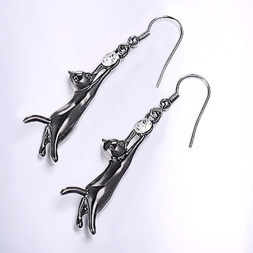 Angled silver-tone cat drop earrings on white background