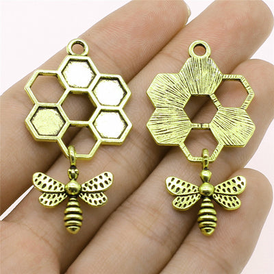 Close-up of honeycomb and bee frame pendants showing open honeycomb cells with a dangling bee motif