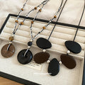 Black and Brown Cord Necklaces with Round Wood Look Pendants view 1