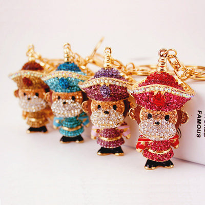 Four rhinestone monkey figures in gold, blue, purple, and pink stand in a row.