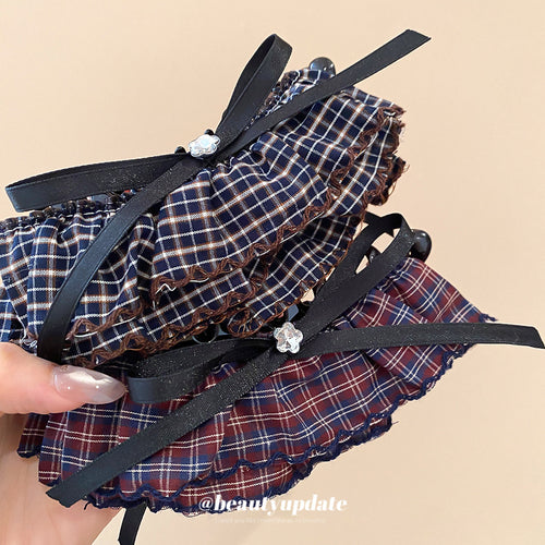 Main image 2 showing two black claw hair clips trimmed with layered plaid fabric bows in red-blue or blue-white, arrange